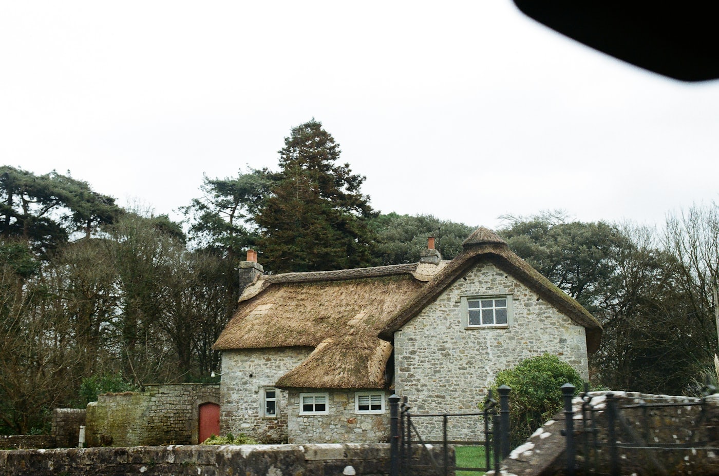 A stone and thatch house in the Vale of Glamorgan under a grey sky